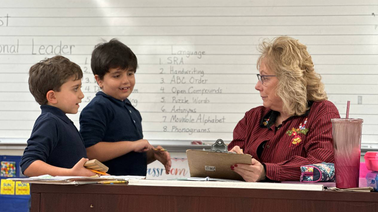 A teacher and her students enjoying an interactive and joyful learning session, characterized by laughter and camaraderie.