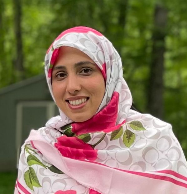 Ms. Hoda smiling while wearing a floral scarf.