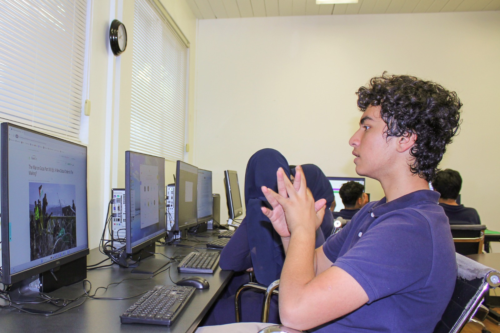 Middle school boy looking at a computer screen in the Guide academy computer lab, other students sitting next to him